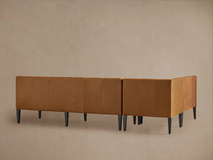 Close-up of a Gates Leather Banquette; rich tan recycled leather with vertical channel-stitched backrest, smooth seat.
