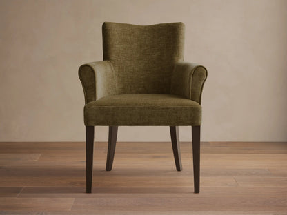 Front view of the olive green Giovanni Dining Arm Chair, featuring a textured upholstery, high back, rolled armrests, and dark wood legs.