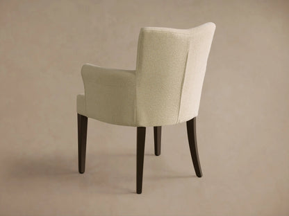 Rear view of the Cream upholstered Giovanni Dining Arm Chair with dark wood tapered legs.