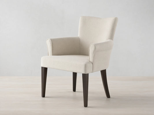 Front view of the cream upholstered Giovanni Dining Arm Chair with dark brown tapered wood legs.