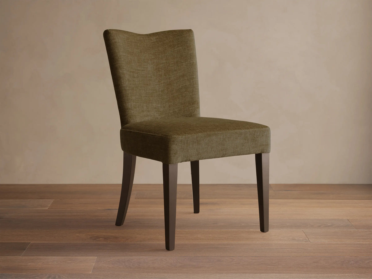 Front view of the olive textured Giovanni Dining Side Chair with a gently curved back and dark wood legs.