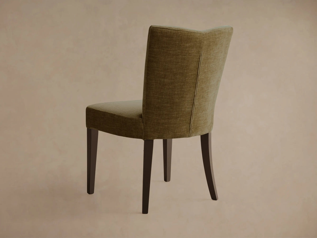 Front view of the olive textured Giovanni Dining Side Chair with a gently curved back and dark wood legs.