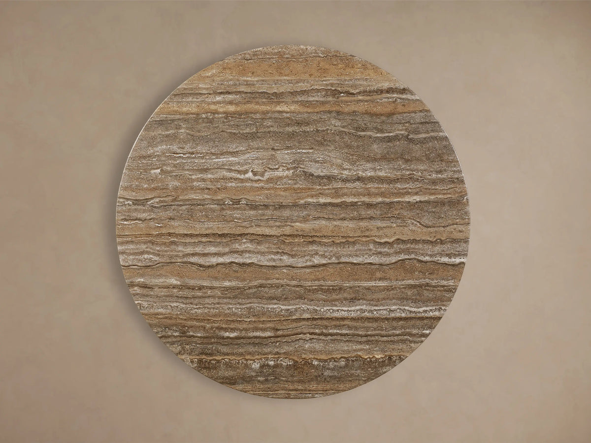 Front view of the Saint Germain Round Stone Dining Table with Dauphine Base. It has a natural stone top and two black oak veneer curved bases.