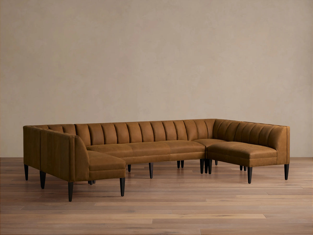Gates Leather U-Shaped Banquette, rich brown, channel-stitched backrests, dark tapered legs on a wooden floor.