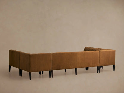 Close-up of a Gates Leather U-Shaped Banquette in rich cognac leather, showing channel-stitched backrests & flat seats.