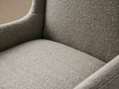 Halstead Dining Chair with high backrest, curved armrests, and textured gray upholstery on dark wood legs, set on a wooden floor.