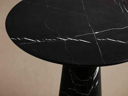 Front view of the Hemmings Bistro Table, a black marble table with a round top and conical base, featuring white veining.