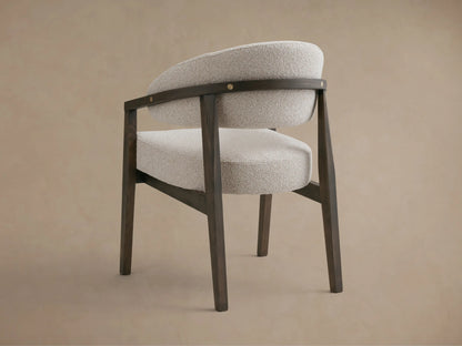 Hagen Dining Chair with solid beech wood frame, curved arms with brass details, light fabric upholstery, and padded seat.