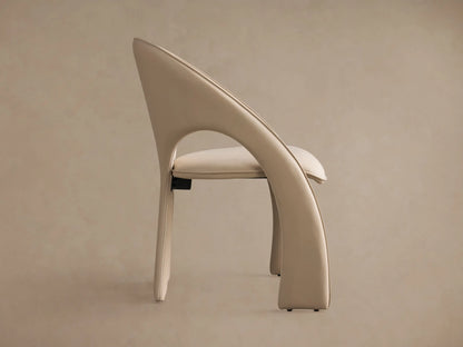 Side profile of the cream Hearst Dining Side Chair, showing its fully upholstered frame, curved back, and padded seat.
