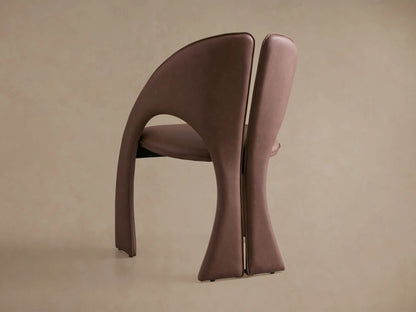 Rear view of two brown Hearst Dining Chairs, featuring curved upholstered backs with visible stitching.