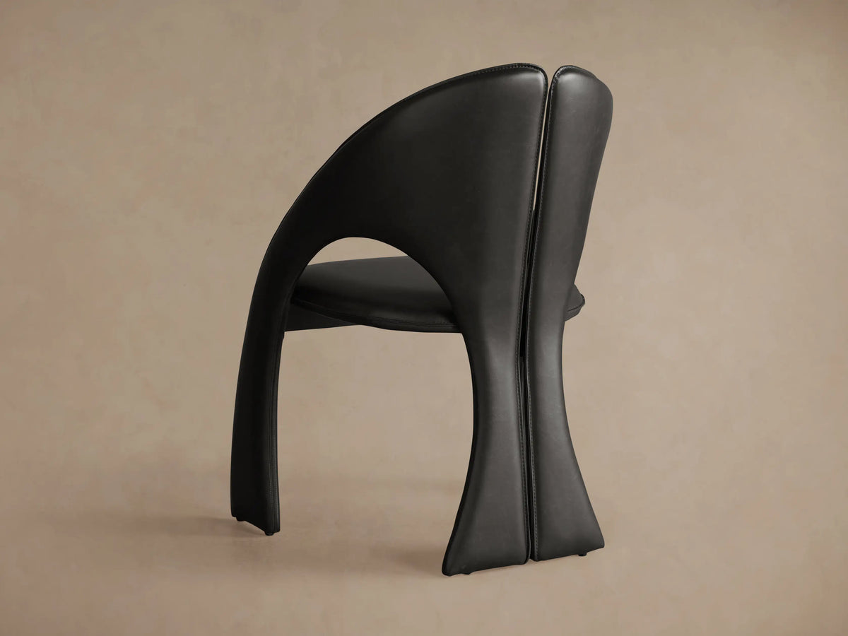 Front view of the Black Hearst Dining Side Chair, featuring a sculptural, curved frame, split back, and backrest cutout.