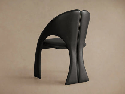 Front view of the Black Hearst Dining Side Chair, featuring a sculptural, curved frame, split back, and backrest cutout.
