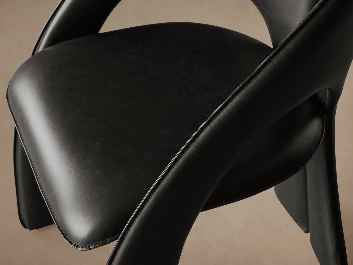 Side profile of the Black Hearst Dining Side Chair, featuring a modern, curved, fully upholstered design.