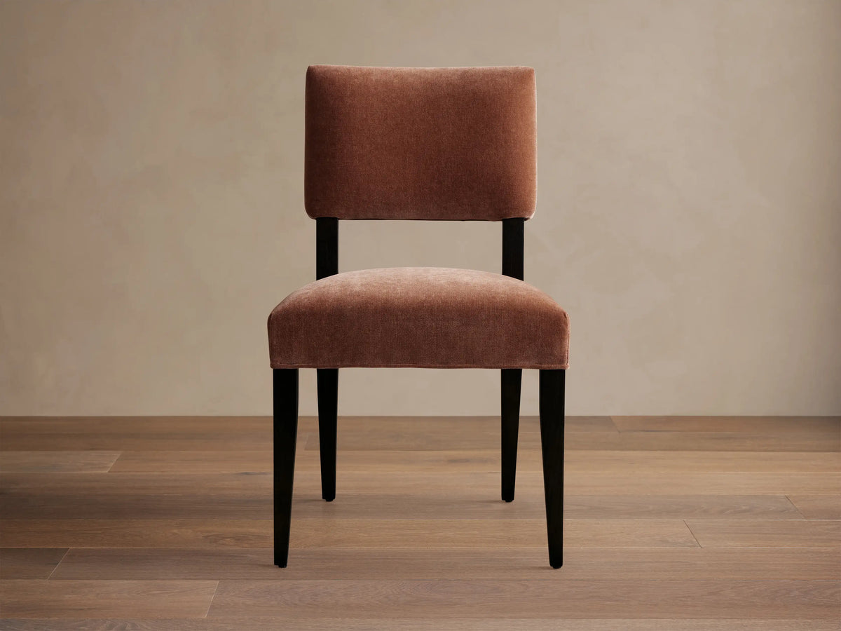 Hartley Dining Chair with rust velvet upholstery, dark tapered & splayed legs, angled on wood floor.