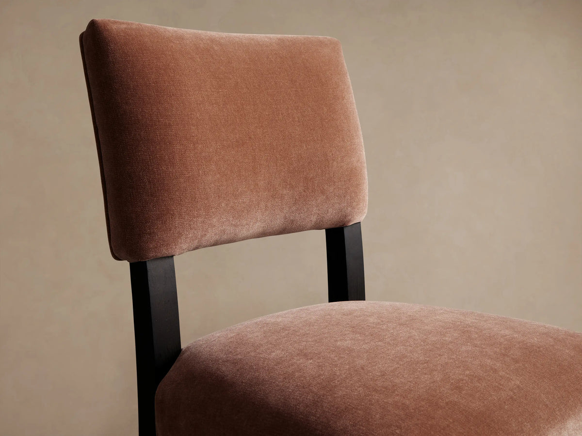 Hartley Dining Chair with reddish-brown velvet upholstery and dark, tapered wooden legs, seen from the front.