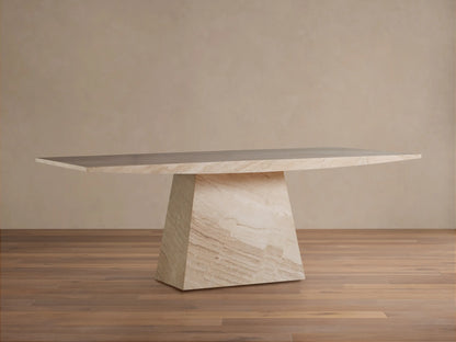 Ilaria Dining Table, crafted from honed beige coralle marble. It has a long rectangular top & a thick, trapezoidal base.