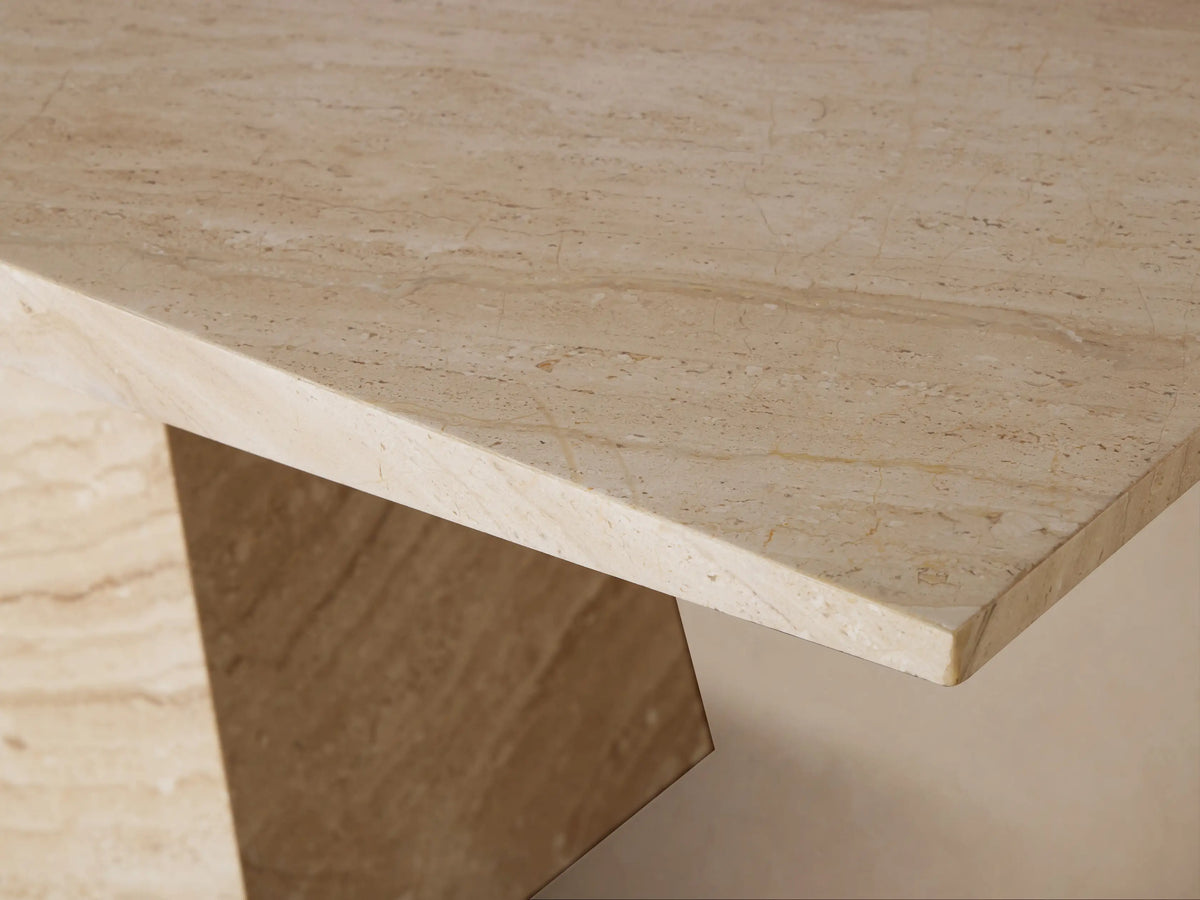Close-up of the Ilaria Dining Table's beige coralle marble top, showing its honed finish and natural brown veining.
