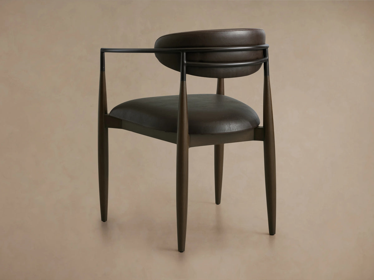 Jagger Faux Leather Dining Arm Chair in Cinder with a curved oil-rubbed bronze frame and rich dark brown faux leather seat and backrest.