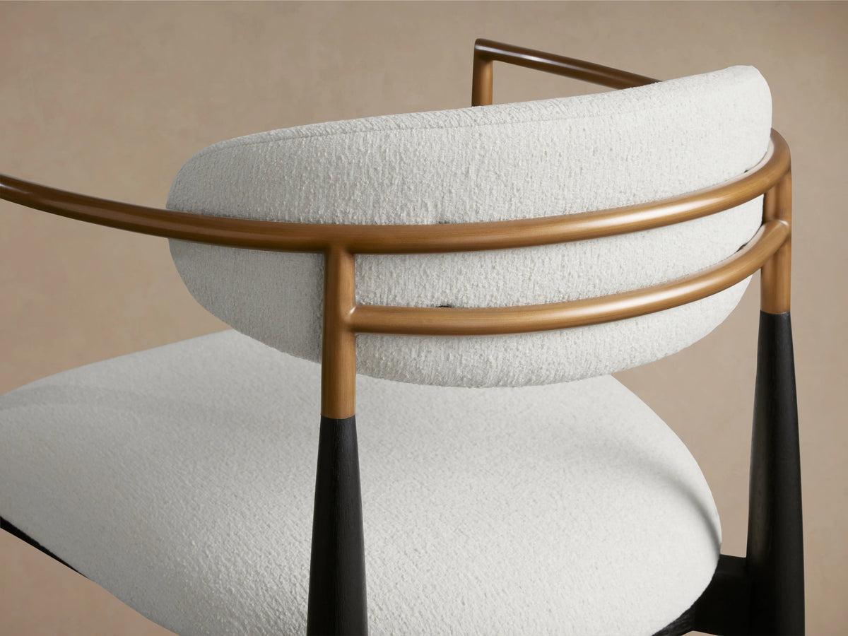 Front view of Jagger Dining Arm Chair with a white cushioned seat and backrest. Black wooden frame with tapered legs and wooden armrest detailing.