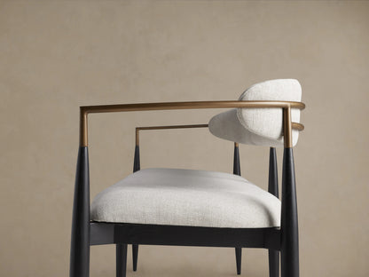 Jagger Dining Bench with light gray cushioned seat and backrest, black slender legs, and wooden floor background.