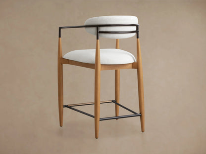 Jagger Stool featuring a wooden frame with a clear lacquer finish, cushioned white seat and backrest, and sleek black metal supports.