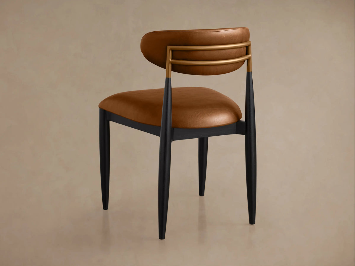 Jagger Faux Leather Dining Side Chair, close-up: curved brown back, brass frame, black leg accents.