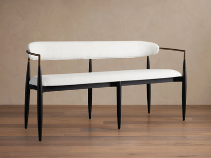 Jagger Dining Bench with sleek black frame and cream cushioned seat and backrest, set on a wooden floor against a neutral wall.