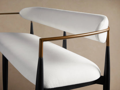 Jagger Dining Bench with sleek black frame, white cushioned seat and back, set in a room with light wood flooring and beige walls.