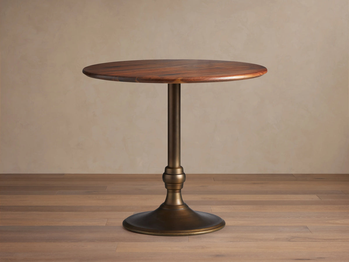 Round Jacob Counter Table with a solid walnut top and a Wade Base in brass finish, set against a light neutral background.