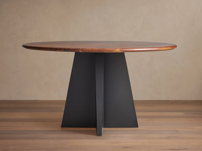 Jacob Round Dining Table with a dark brown walnut top & black geometric Vertex base, shown centered on a wood floor.