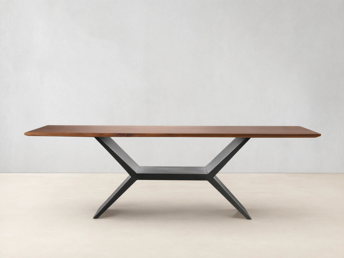 Jacob Dining Table with a rectangular brown walnut wood top on a dark, geometric vertex base, centered against a beige wall.