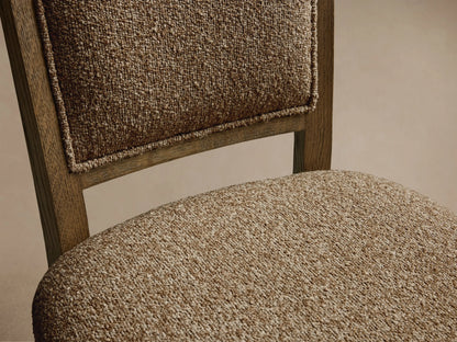 Front view of the Jeannine Upholstered Camel Back Dining Side Chair, with textured beige upholstery and an oak frame.