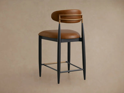 Jagger Faux Leather Armless Stool with brown faux leather seat and backrest, black frame and legs, on wooden floor.
