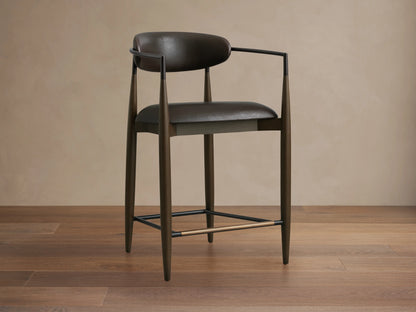 Jagger Faux Leather Stool featuring dark brown faux leather seat and backrest, sleek metal frame, and footrest.