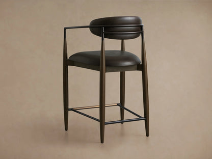 Dark brown Jagger Faux Leather Stool with curved backrest, faux leather upholstery, and metal accents over wooden legs.