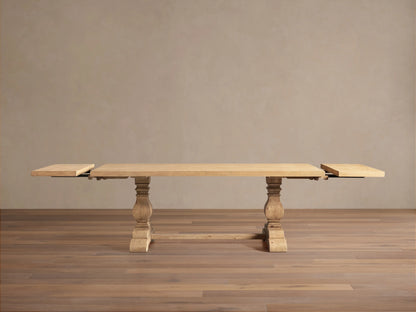 Kensington Dining Table: Long, light natural oak table with two carved pedestal bases & leaf extensions, on wood floor.