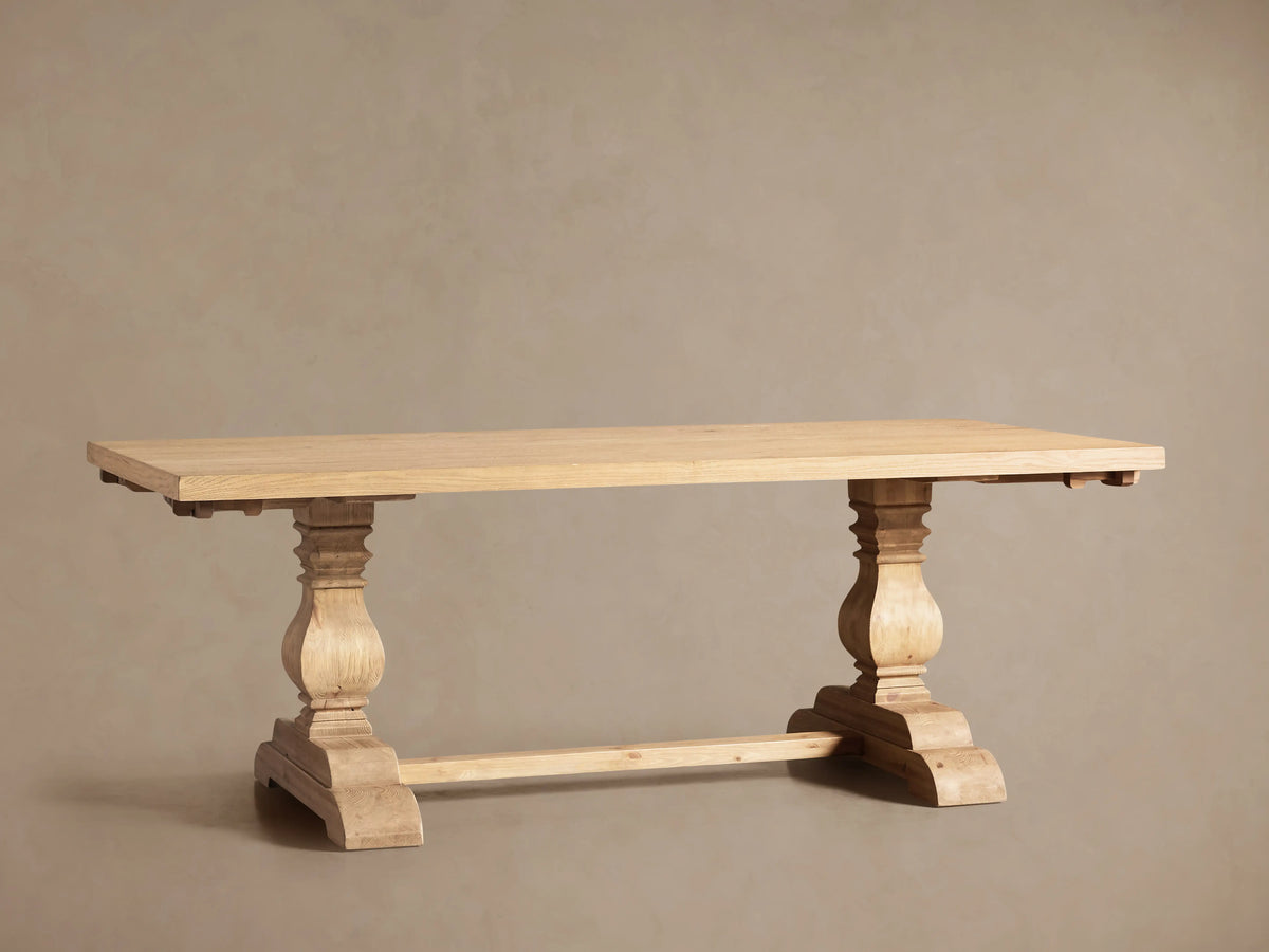 Light natural oak Kensington Dining Table with two ornate pedestal bases. Extension leaves are partially pulled out at both ends.