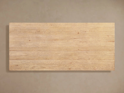 Angled close-up of Kensington Dining Table's light oak plank top with distinct wood grain, texture. Part of a carved base.