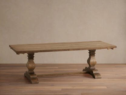 Kensington Reclaimed Dining Table with a rustic wooden finish, features a rectangular top and two ornate pedestal bases on a wooden floor.