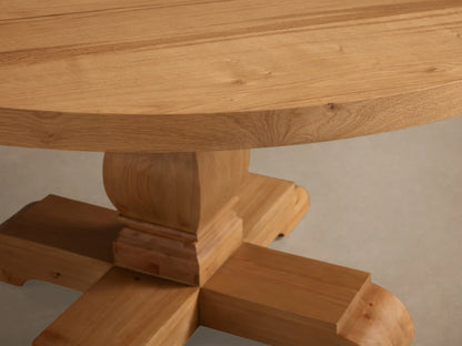 Close-up of the natural wood Kensington Round Reclaimed Dining Table, highlighting its round top and sculptural pedestal base.