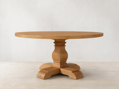 Front view of the Kensington Round Reclaimed Dining Table, a light wood round table with a sculpted pedestal base.