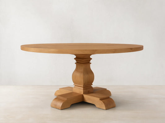Front view of the Kensington Round Reclaimed Dining Table, a light wood round table with a sculpted pedestal base.