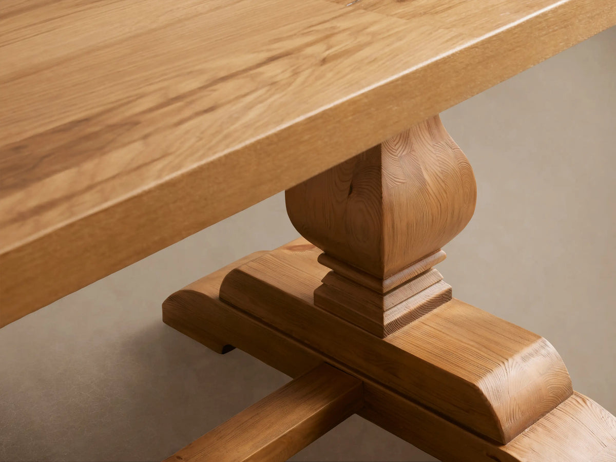 Kensington Reclaimed Dining Table, light natural wood, rectangular top, two ornate pedestal bases with stretcher, on wood floor.