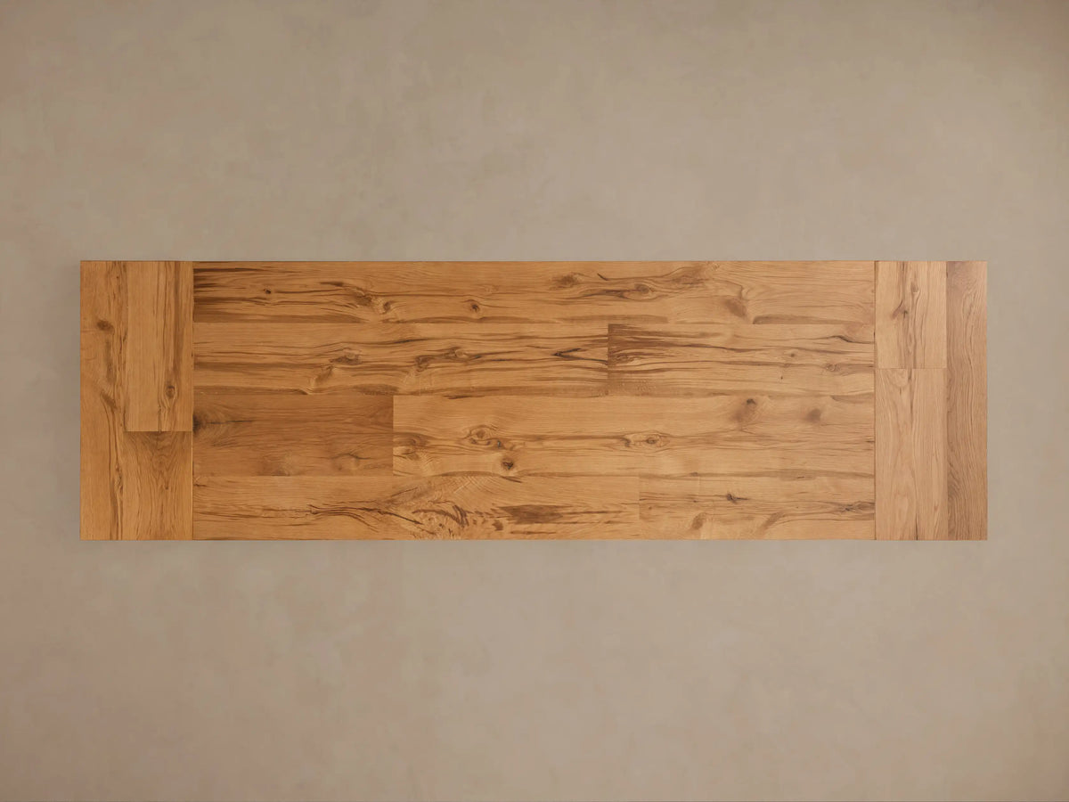 Close-up of Kensington Reclaimed Dining Table showing natural wood grain on light brown oak top & ornate pine pedestal base.