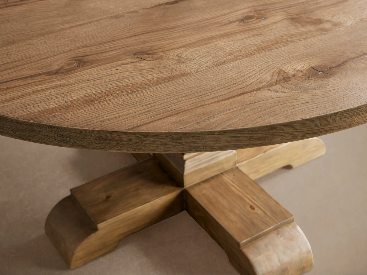 Kensington Round Reclaimed Dining Table with a round oak veneer top and a sturdy, handcrafted Finnish pine pedestal base on wooden floor.