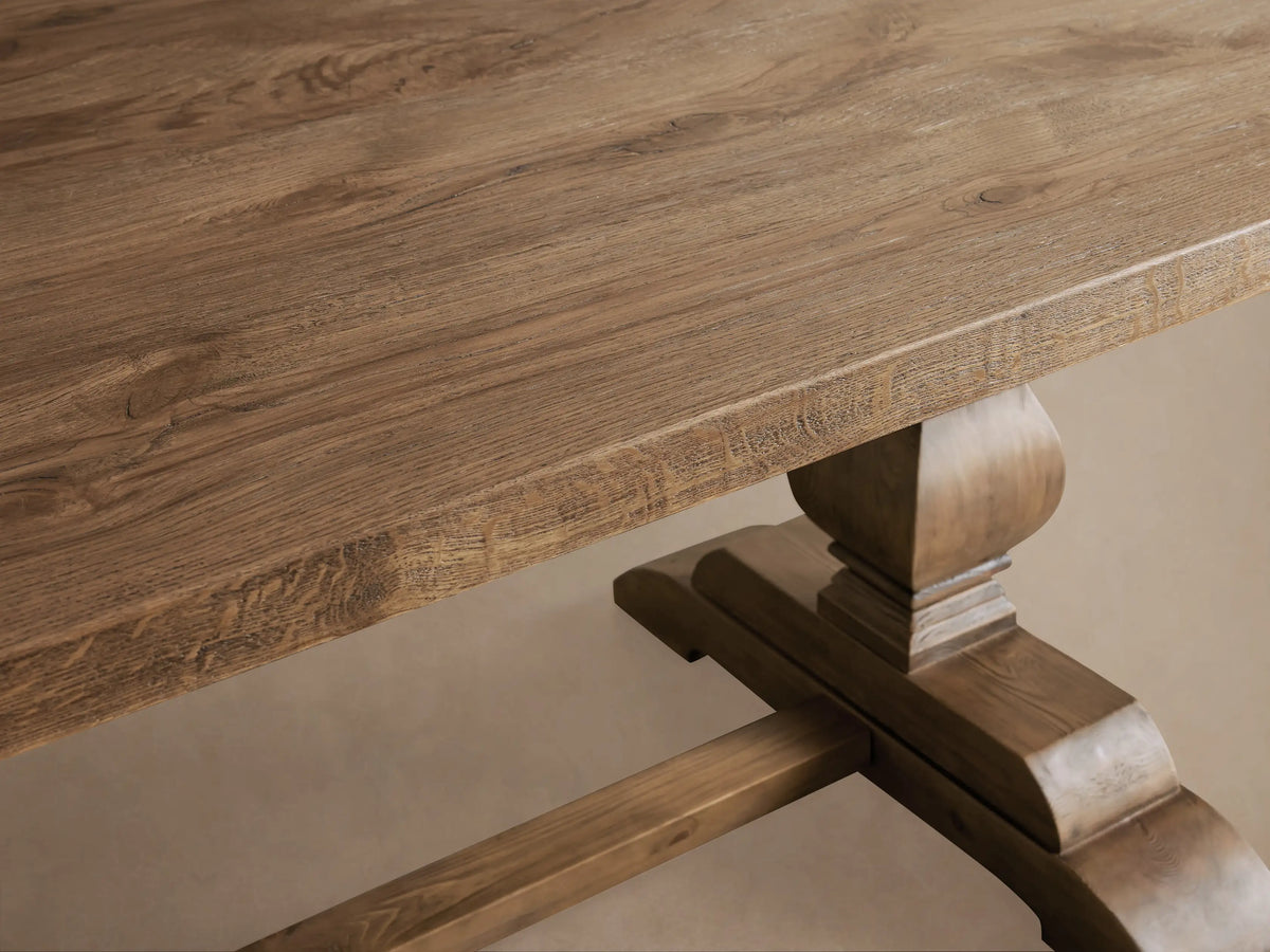 Kensington Reclaimed Dining Table with a rectangular top and two ornate pedestal legs on a wooden floor, in natural wood finish.