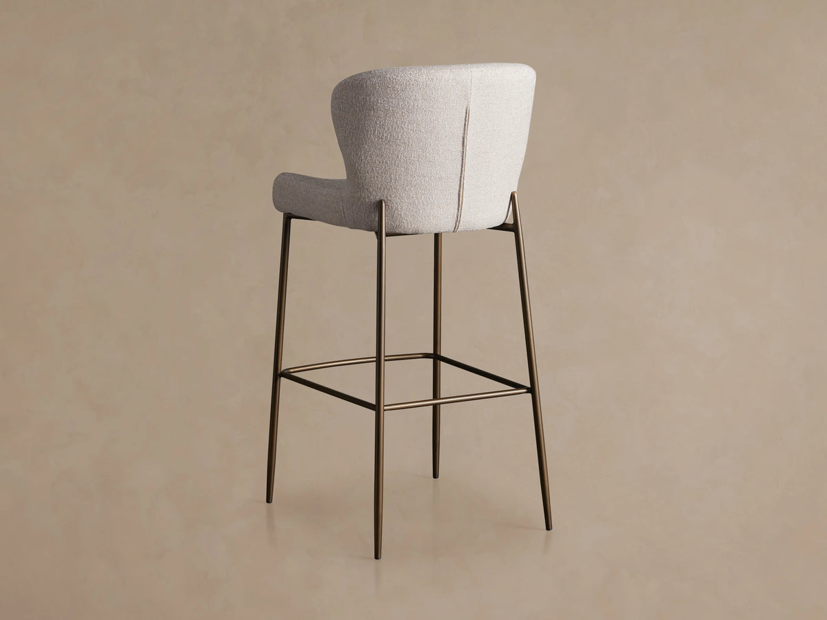Kirsten Stool in Nona Linen, featuring a high back, light fabric upholstery, and slender iron legs with a footrest.