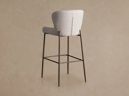 Kirsten Stool in Nona Linen, featuring a high back, light fabric upholstery, and slender iron legs with a footrest.