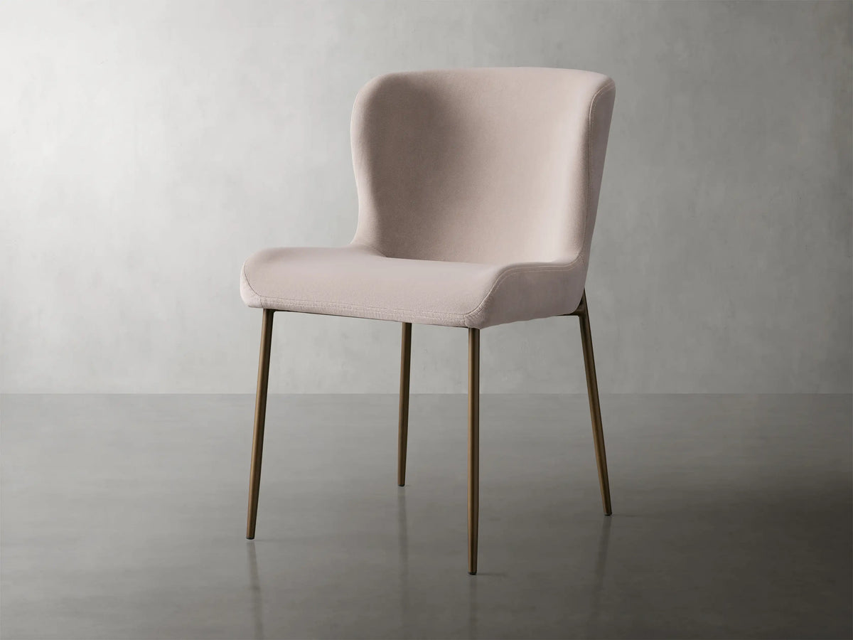 Kirsten Dining Chair in Vanni Linen featuring a soft pink upholstered seat and curved backrest, with slender powder-coated iron legs.