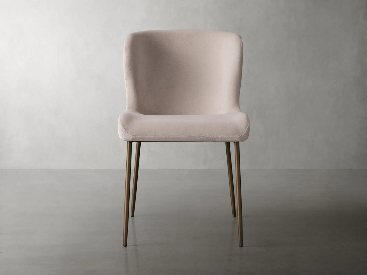Kirsten Dining Chair in Vanni Linen featuring a soft pink upholstered seat and curved backrest, with slender powder-coated iron legs.